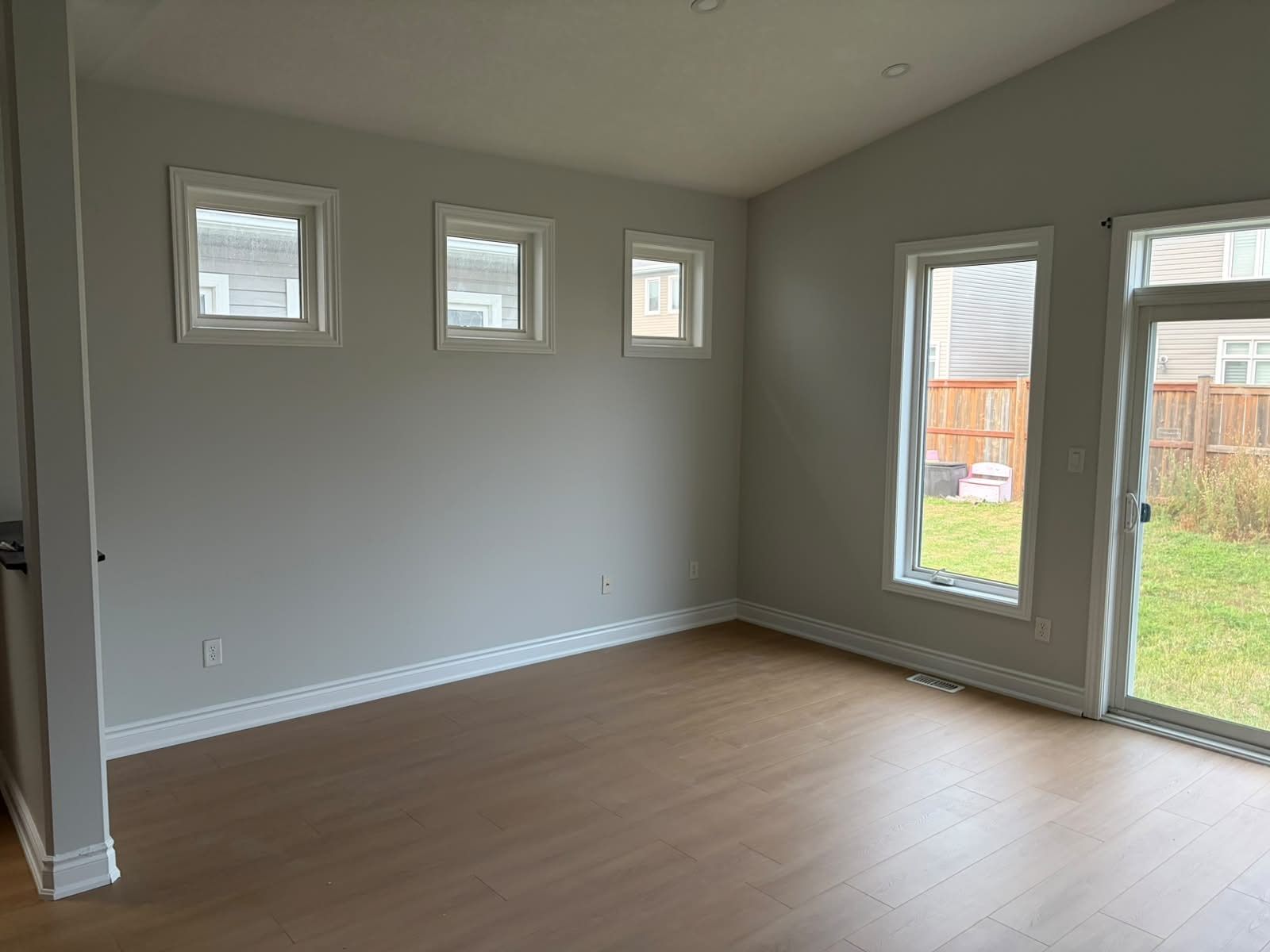A great room with a two-storey window wall, walls and ceiling freshly painted